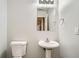 Bathroom featuring a white toilet and pedestal sink with a large mirror at 7078 Ravenwood Ln, Lithonia, GA 30038