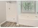 Bathroom featuring a shower and a large soaking tub with a window at 7078 Ravenwood Ln, Lithonia, GA 30038