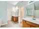 Bathroom with double sinks, wood cabinets, a large mirror, and natural light at 7078 Ravenwood Ln, Lithonia, GA 30038