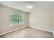 This bedroom features gray walls, gray flooring, and a large window letting in plenty of natural light at 7078 Ravenwood Ln, Lithonia, GA 30038