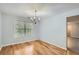 Elegant dining room with a chandelier, hardwood floors, and large windows at 7078 Ravenwood Ln, Lithonia, GA 30038