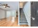 Bright living room with hardwood floors, a ceiling fan, and staircase at 7078 Ravenwood Ln, Lithonia, GA 30038