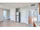 Living room area featuring hard flooring with an open space and stainless steel refrigerator at 7078 Ravenwood Ln, Lithonia, GA 30038