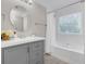 Modern bathroom showcasing a shower-tub, window, and gray cabinets at 1039 Fern Se Ave, Atlanta, GA 30315