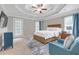 Main bedroom with a tray ceiling, fan, TV, and a comfortable sitting area bathed in natural light at 1039 Fern Se Ave, Atlanta, GA 30315