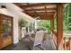 Inviting covered porch featuring a comfortable seating area, and natural surroundings at 114 Karland Nw Dr, Atlanta, GA 30305