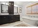 Spa-like bathroom features freestanding tub, marble countertops, dark cabinets, and neutral paint at 114 Karland Nw Dr, Atlanta, GA 30305