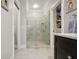 Modern bathroom with glass shower, marble floors, neutral paint, and black cabinets at 114 Karland Nw Dr, Atlanta, GA 30305