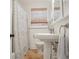 Bright bathroom featuring a pedestal sink, tiled floor, patterned shower curtain, and window with woven blind at 114 Karland Nw Dr, Atlanta, GA 30305