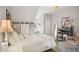 Bedroom with high ceiling, barn door, white bedding, gray storage, and decorative accents at 114 Karland Nw Dr, Atlanta, GA 30305