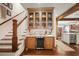 Wet bar adjacent to staircase featuring custom cabinets, marble countertop and wine cooler at 114 Karland Nw Dr, Atlanta, GA 30305