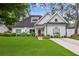 Charming home boasts a well-manicured lawn, beautiful landscaping, and a welcoming wood front door at 114 Karland Nw Dr, Atlanta, GA 30305