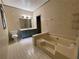 Bright bathroom with tile floors, a sunken tub, and blue vanity at 1935 Lamp Post Ln, Lawrenceville, GA 30043