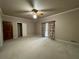 Large bedroom featuring carpeted floors, ceiling fan and window with curtains at 1935 Lamp Post Ln, Lawrenceville, GA 30043