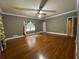 A spacious bedroom showcasing hardwood floors, neutral walls, and a ceiling fan at 1935 Lamp Post Ln, Lawrenceville, GA 30043
