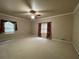Spacious carpeted bedroom featuring a ceiling fan and natural light from two windows at 1935 Lamp Post Ln, Lawrenceville, GA 30043
