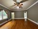 Spacious bedroom with hardwood floors, neutral paint, crown molding, and a ceiling fan at 1935 Lamp Post Ln, Lawrenceville, GA 30043