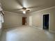 Spacious bedroom with carpeted floors, ceiling fan, and multiple doorways at 1935 Lamp Post Ln, Lawrenceville, GA 30043