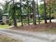 Brick home with mature trees, lush landscaping, and a long driveway to the front of the home at 1935 Lamp Post Ln, Lawrenceville, GA 30043