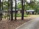Brick home with mature trees, lush landscaping, and a long driveway to the front of the home at 1935 Lamp Post Ln, Lawrenceville, GA 30043