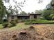 Brick home with mature trees, lush landscaping, and a covered porch in front of the entrance at 1935 Lamp Post Ln, Lawrenceville, GA 30043