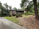 Brick home with mature trees, lush landscaping, and a covered porch in front of the entrance at 1935 Lamp Post Ln, Lawrenceville, GA 30043