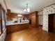 Spacious kitchen featuring wood cabinets, an island, hardwood floors, and neutral countertops at 1935 Lamp Post Ln, Lawrenceville, GA 30043