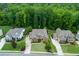 Aerial view of three homes with well-maintained lawns and lush trees at 225 Sundance Dr, Woodstock, GA 30188