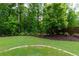 Backyard featuring mature trees, beautiful landscaping, and a well-maintained lawn at 225 Sundance Dr, Woodstock, GA 30188