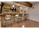 Basement bar area with stone accents, wooden shelves, and comfortable seating at 225 Sundance Dr, Woodstock, GA 30188