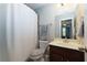 Cozy bathroom features a toilet, a vanity with sink and a shower with a white shower curtain at 225 Sundance Dr, Woodstock, GA 30188