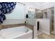 Bathroom featuring a soaking tub with tile surround and a glass-enclosed shower at 225 Sundance Dr, Woodstock, GA 30188