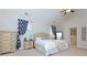 Bright bedroom featuring a beige upholstered headboard, ensuite bathroom, and blue patterned curtains at 225 Sundance Dr, Woodstock, GA 30188