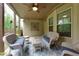 Relaxing covered patio features neutral paint, ceiling fan, and comfortable seating arrangements at 225 Sundance Dr, Woodstock, GA 30188