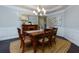 Formal dining room with wooden table, chairs, chandelier, and wainscoting detail at 225 Sundance Dr, Woodstock, GA 30188