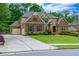 Traditional brick home with a well-manicured lawn, long driveway and attached two-car garage at 225 Sundance Dr, Woodstock, GA 30188