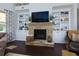 Stone fireplace with built-in shelving and dark hardwood floors at 225 Sundance Dr, Woodstock, GA 30188