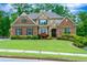 Charming brick and stone home with a beautifully landscaped front yard and mature trees at 225 Sundance Dr, Woodstock, GA 30188