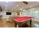 Open-concept basement game room with a pool table, bar area, and cozy seating at 225 Sundance Dr, Woodstock, GA 30188