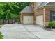 Spacious two-car garage with neutral doors, side yard, and a wide driveway at 225 Sundance Dr, Woodstock, GA 30188