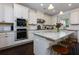 Charming kitchen features stainless steel appliances, granite countertops, and a large island with barstool seating at 225 Sundance Dr, Woodstock, GA 30188