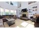 Living room featuring a stone fireplace, built-in shelving, and large windows at 225 Sundance Dr, Woodstock, GA 30188