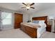Spacious main bedroom with a ceiling fan, carpeted floors, natural light, and dark wood furniture at 225 Sundance Dr, Woodstock, GA 30188