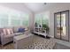 Bright sunroom featuring a comfortable sofa, decorative pillows, stylish rug, and a door to the outside at 225 Sundance Dr, Woodstock, GA 30188