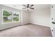 An airy bedroom with a ceiling fan and large window offering lots of natural light and a view of the neighborhood at 2889 Windsor Knoll Dr, Dacula, GA 30019