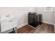 A practical laundry room equipped with a utility sink, black washer and dryer at 2889 Windsor Knoll Dr, Dacula, GA 30019