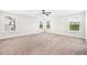 A spacious main bedroom features neutral carpet, multiple windows, and a ceiling fan at 2889 Windsor Knoll Dr, Dacula, GA 30019