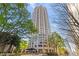 An exterior view of a high-rise building surrounded by lush green trees against a clear blue sky at 3475 Oak Valley Ne Rd # 950, Atlanta, GA 30326