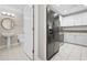 View from bathroom to kitchen with stainless steel appliances, black refrigerator and white cabinets at 3475 Oak Valley Ne Rd # 950, Atlanta, GA 30326