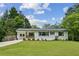 Charming renovated ranch-style home featuring a freshly painted white brick exterior and a well-manicured lawn at 1477 Spruce Se Dr, Smyrna, GA 30080